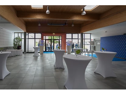 Tagungshotels - Foyer mit hauseigenen runden Stehtischen mit weißen Hussen + Dekolichtkugeln + Fotobereich + Buffetbereich - Seifenfabrik Veranstaltungszentrum