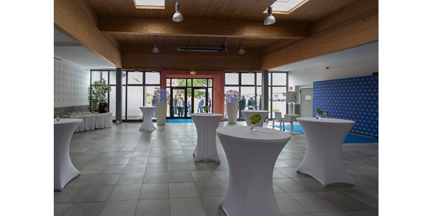 Tagungshotels - Flair: rustikal - Graz - Foyer mit hauseigenen runden Stehtischen mit weißen Hussen + Dekolichtkugeln + Fotobereich + Buffetbereich - Seifenfabrik Veranstaltungszentrum
