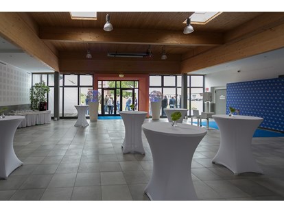 Tagungshotels - Garderobe - Foyer mit hauseigenen runden Stehtischen mit weißen Hussen + Dekolichtkugeln + Fotobereich + Buffetbereich - Seifenfabrik Veranstaltungszentrum