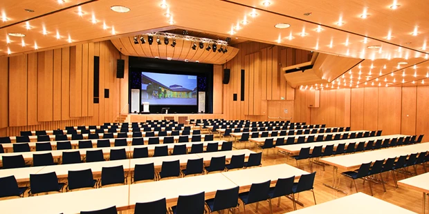 Tagungshotels - Beamer und Leinwand - Großer Saal mit parlamentarischer Bestuhlung und Podest auf der Bühne - Stadthalle Erding