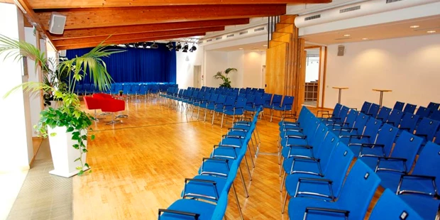 Tagungshotels - Beamer und Leinwand - Kleiner Saal mit Reihenbestuhlung und mittiger Bühne - Stadthalle Erding