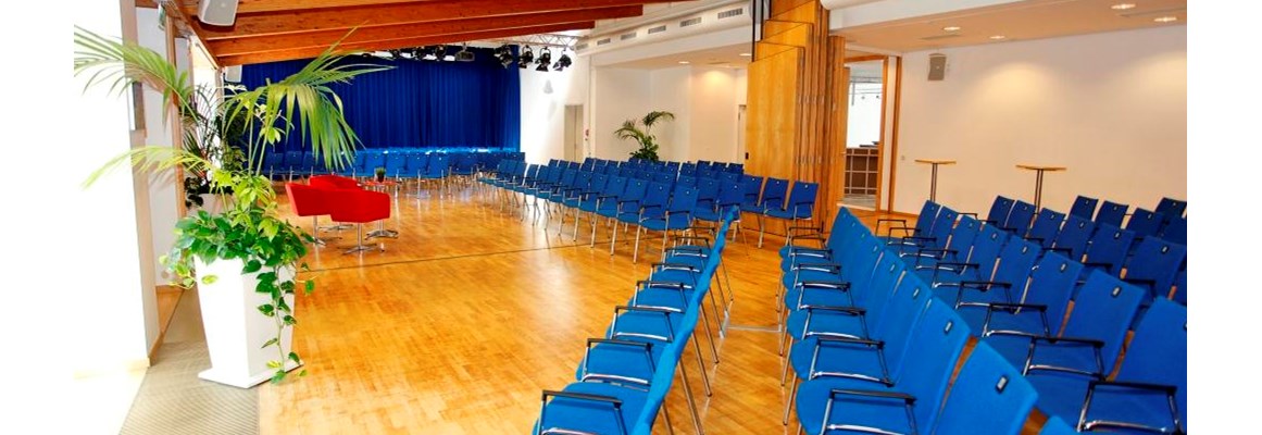 Seminarraum: Kleiner Saal mit Reihenbestuhlung und mittiger Bühne - Stadthalle Erding