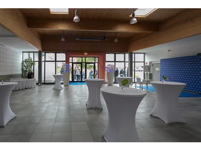 Tagungshotels - Portier: kein Portier - Foyer mit hauseigenen runden Stehtischen mit weißen Hussen + Dekolichtkugeln + Fotobereich + Buffetbereich - Seifenfabrik Veranstaltungszentrum