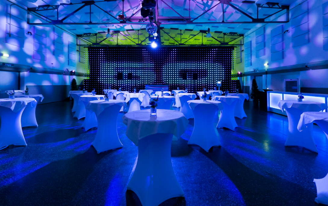 Seminarraum: Markthalle mit Bühne & LED-Wall + Ambientelicht mit Projektionen + hauseigenen runden Stehtischen mit Hussen + beleuchteten Bars - Seifenfabrik Veranstaltungszentrum